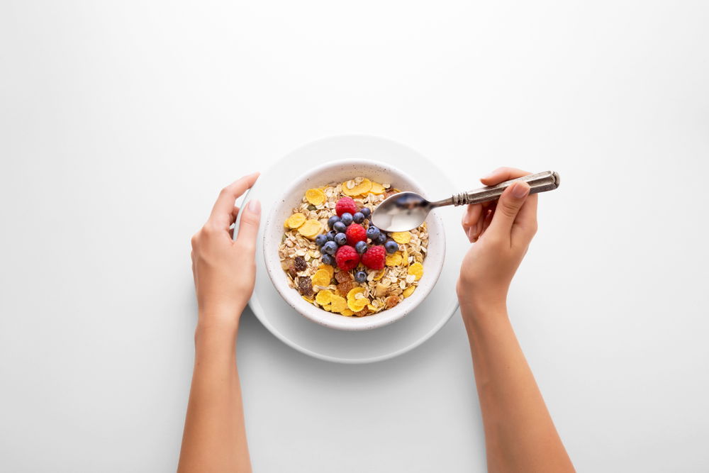 Young,Woman,Eating,Muesli,Cereal,Breakfast,With,Berry,Fruit,In